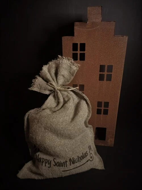 Decoratieve jute zak Sinterklaas met tekst bij een roestig huis
