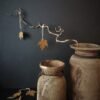 Roestig metalen blad aan een tak, geplaatst in een oude Nepalese pot