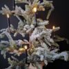 Zwarte klem LED kerstboomkaars in een kunst dennenboom met sneeuw