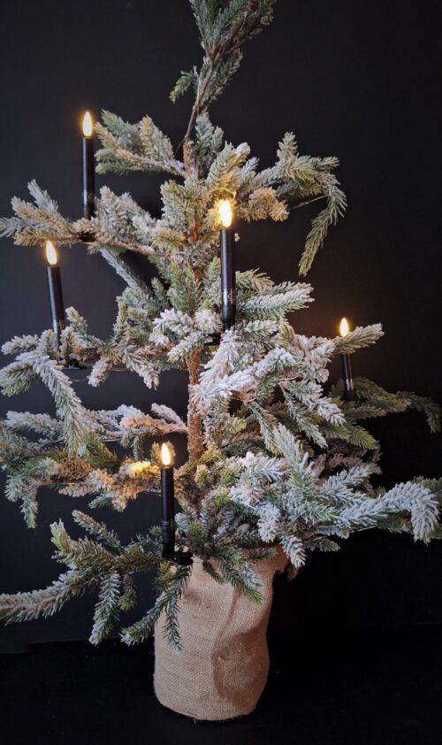 Zwarte klem LED kerstboomkaars in een kunst dennenboom met sneeuw