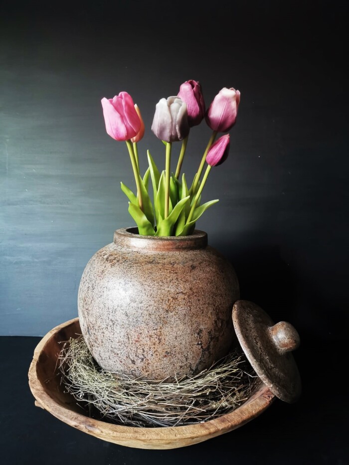 Bruine ronde pot met deksel met real touch tulpen in een oude houten schaal