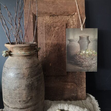 Deco bordje nest aan een oud deurtje met een Nepalese pot, shabby doek en kwartel eieren