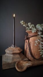 Gotische LED dinerkaarsen van 38cm op een oude houten poer, met een Nepalese kruik en een kunsttak eucalyptisch