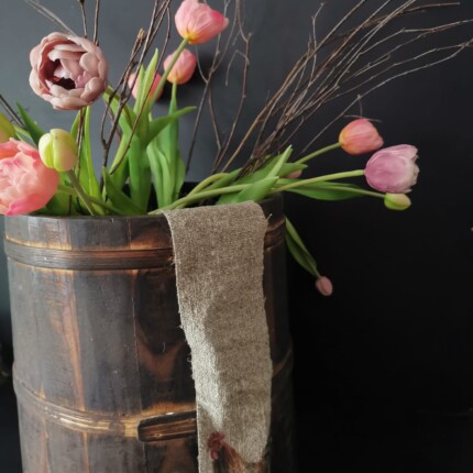 Linnen lint haan in houten pot met tulpen