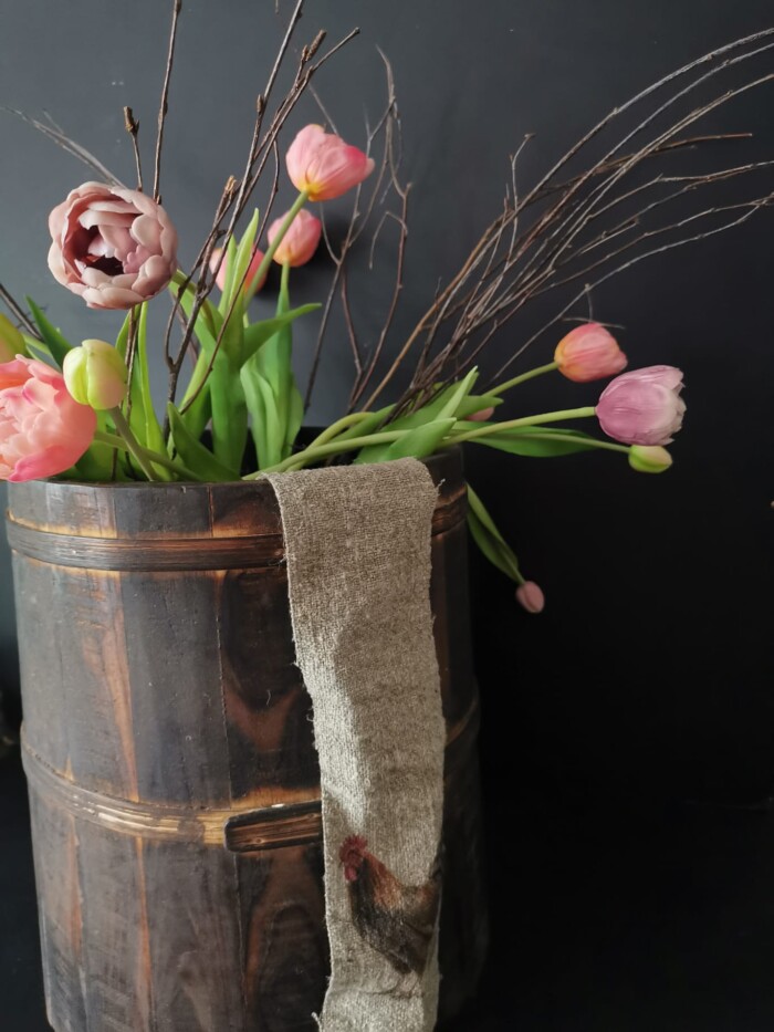 Linnen lint haan in houten pot met tulpen