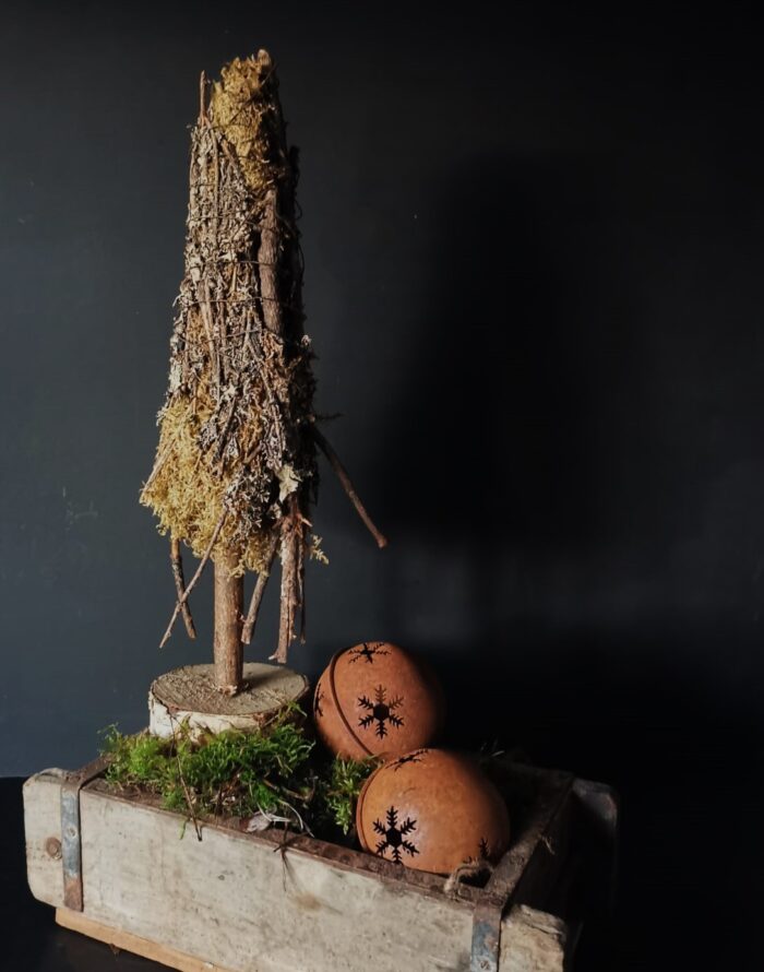 Roestige ronde bellen in een houten steenmal met een mosboompje