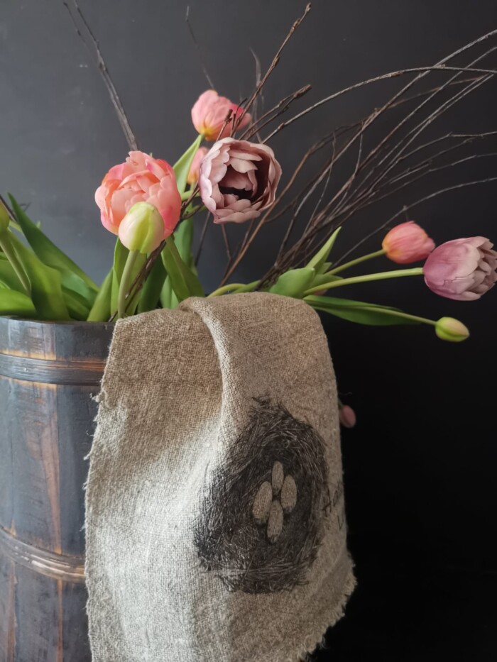 Shabby doekje nest met ei op een houten pot met tulpen