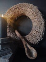 Takken krans met oude houten poer en houten lepel.