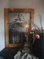 Tuinposter leemmand met kunsttulpen in oude houten pot en oer kandealaar.