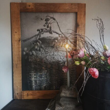 Tuinposter leemmand met kunsttulpen in oude houten pot en oer kandealaar.