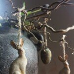 Haas-hanger aan hazelaar takken in een stenen pot