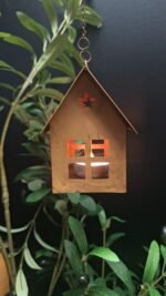 Metalen roesthuisje van 12 cm, hangend aan decoratieve tak – sobere landelijke woonstijl