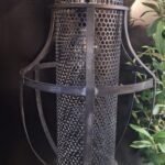 Grijze metalen hanglamp met geperforeerde onderzijde – sobere verlichting aan ketting