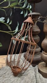 Kooi hanger van metaal aan houten tak