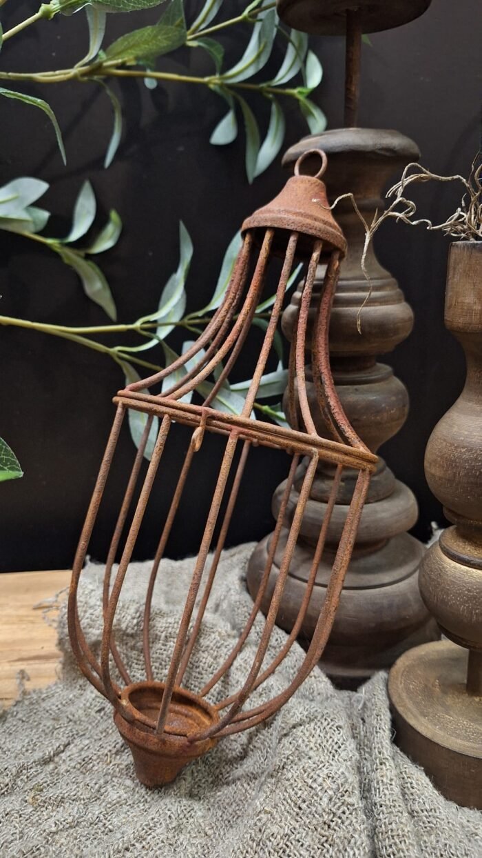 Kooi hanger van metaal aan houten tak