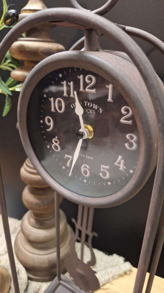 Detail van de zwarte metalen klok en wijzerplaat