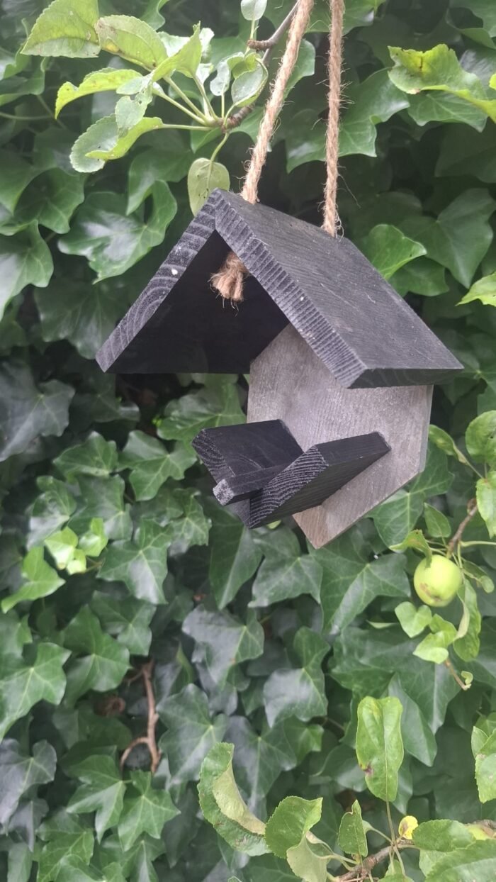 Zwart houten pindakaashuisje voor vogels in landelijke stijl voor tuin of balkon