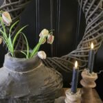 Leemkrans 50cm met daarvoor een vismand gevuld met kievietsbloemen en houten kandelaars met LED kaarsen