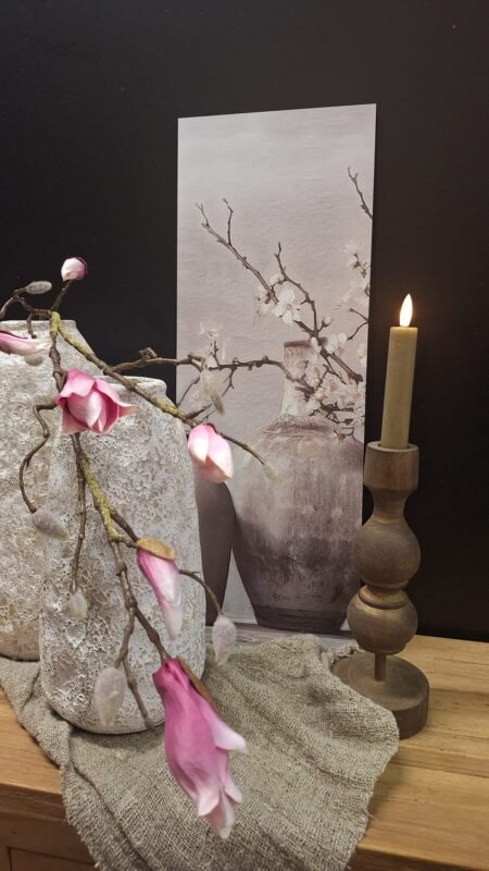 Landelijk wandbord met afbeelding van kruik en magnolia tak, decoratief met witte vaas en houten kandelaar met kaars, sfeervolle landelijke woondecoratie.