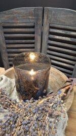 Sfeervol brandend windlicht old brown glas in landelijke setting