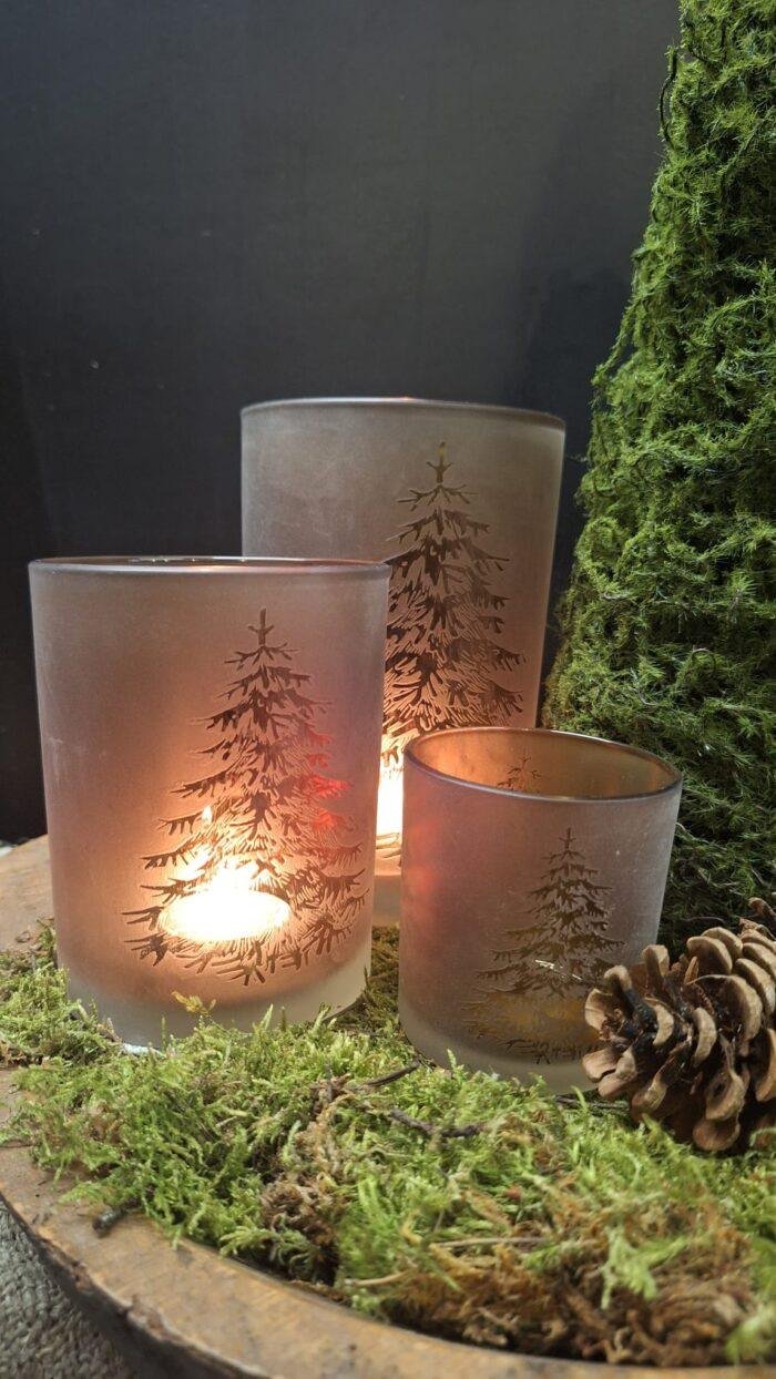 Landelijke kerstdecoratie met windlicht en dennenboomprint.