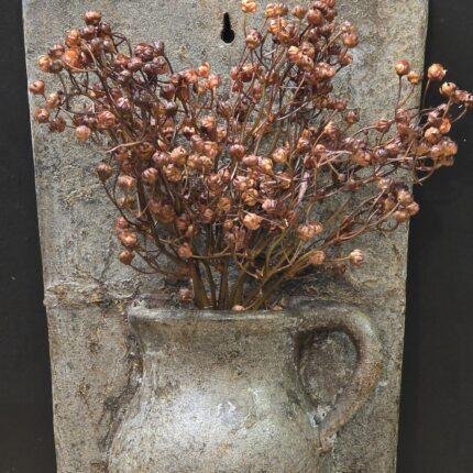 Stenen wandbord met pot